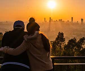 couple watches sunrise over city